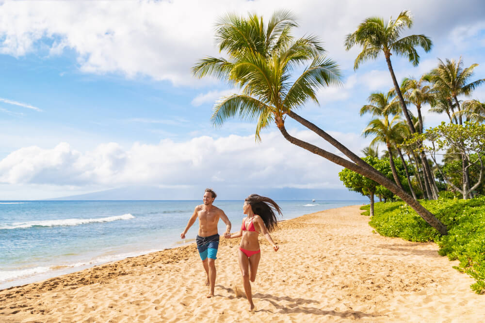 Two people enjoy a day on a Hawaii beach while paying attention to safety.